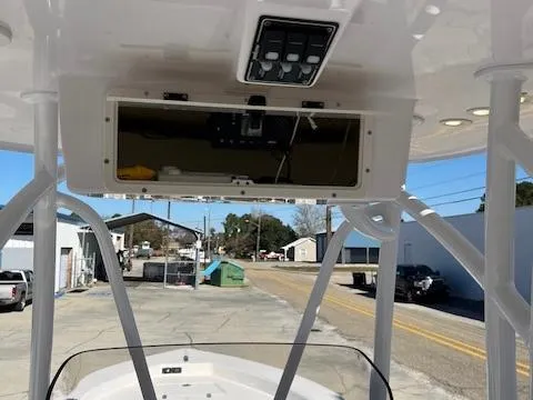Slide: The Image of 2018 BlackJack 256 Bay boat console with overhead electronics compartment, docked in a marina. - 9
