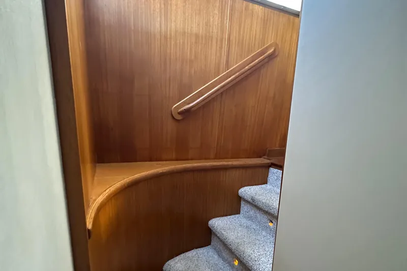 Slide: The Image of Interior staircase of 1990 Tollycraft 57 Wide Body yacht with wooden paneling and carpeted steps. - 12
