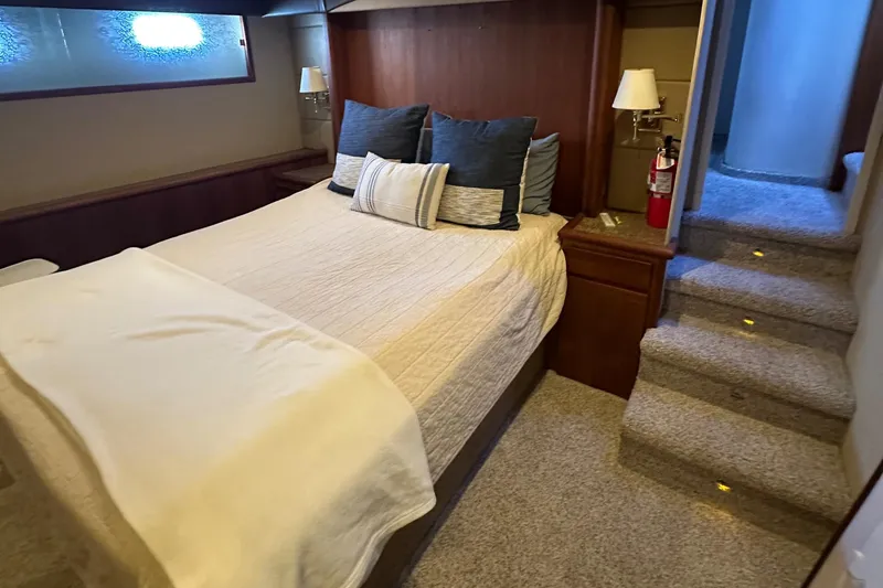 Slide: The Image of Luxurious bedroom interior of a 1990 Tollycraft 57 wide body yacht with cozy bedding. - 17
