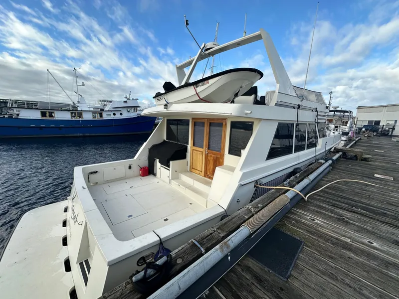 Slide: The Image of 1990 Tollycraft 57 wide body yacht docked at marina under blue sky. - 2