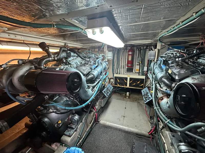 Slide: The Image of Engine room of 1990 Tollycraft 57 Wide Body yacht, featuring dual engines and fire extinguisher. - 21