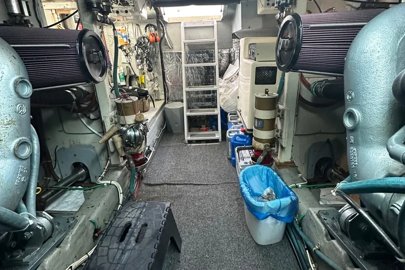 Slide: The Image of Engine room of 1990 Tollycraft 57 wide body yacht, featuring mechanical equipment and storage. - 25