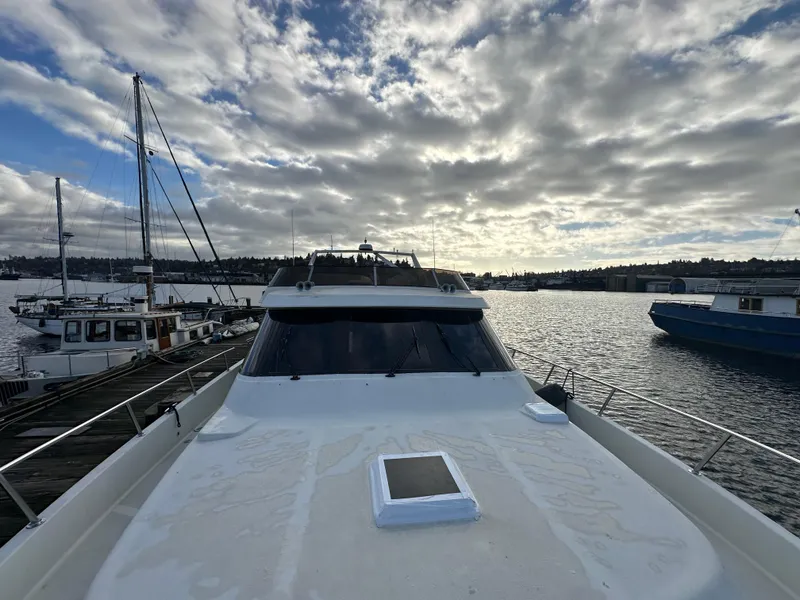 Slide: The Image of 1990 Tollycraft 57 Wide Body yacht docked under cloudy sky. - 3