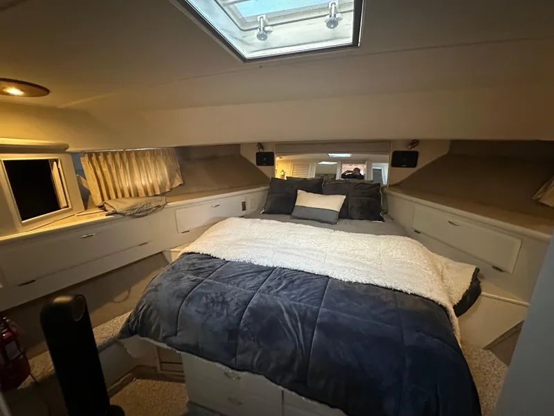 Slide: The Image of Luxurious bedroom interior of 1990 Tollycraft 57 Wide Body yacht with skylight and cozy bedding. - 7