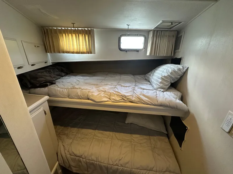 Slide: The Image of Bunk beds in 1990 Tollycraft 57 wide body yacht cabin with window and curtains. - 9