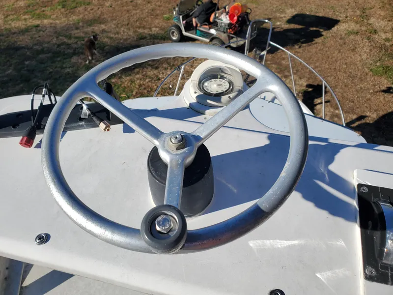 Slide: The Image of 1986 Sport-Craft Sportfisher steering wheel on deck, with compass and controls visible. - 20