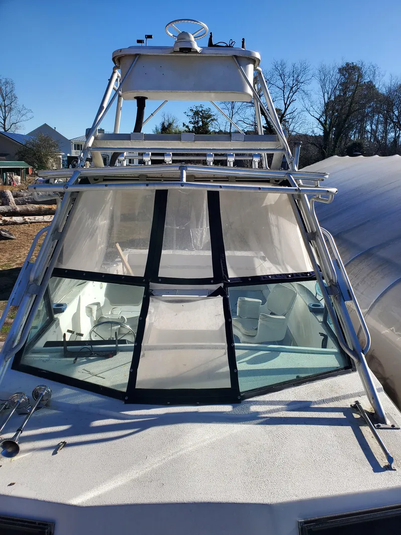 Slide: The Image of 1986 Sport-Craft Sportfisher boat with clear windows and upper deck, docked outdoors. - 32