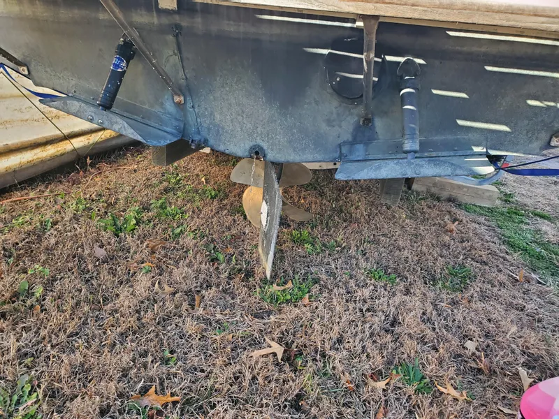 Slide: The Image of 1986 Sport-Craft Sportfisher boat propeller and rudder on dry grass. - 34