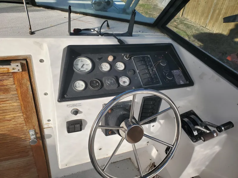 Slide: The Image of 1986 Sport-Craft Sportfisher boat dashboard with steering wheel and control panel. - 8
