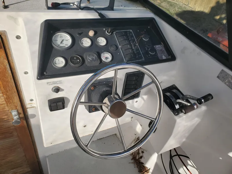 Slide: The Image of 1986 Sport-Craft Sportfisher boat dashboard with steering wheel and control panel. - 9