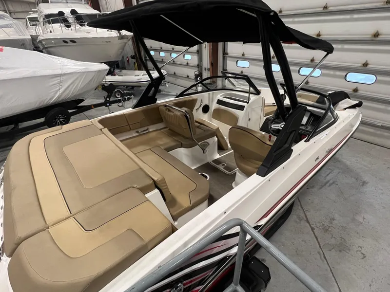 Slide: The Image of 2022 Bayliner VR5 Bowrider I/O with tan interior, black canopy, in a storage facility. - 18