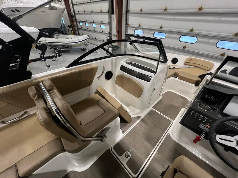 Slide: The Image of 2022 Bayliner VR5 Bowrider I/O interior with tan seating and modern dashboard. - 21