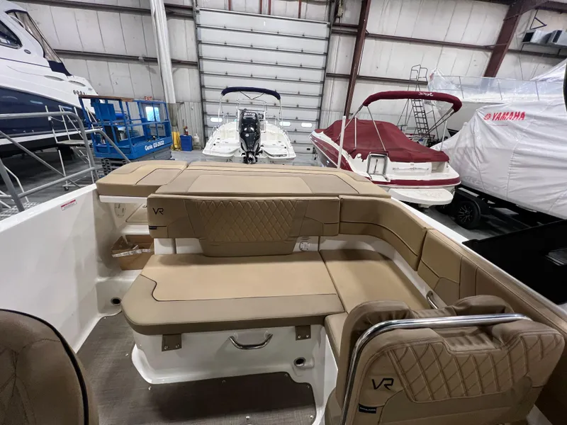 Slide: The Image of 2022 Bayliner VR5 Bowrider I/O interior with tan seating in a boat showroom. - 23