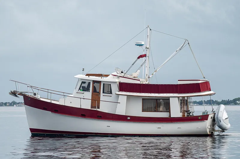 The Image of 1988 Kadey-Krogen 42 boat with red and white design on calm water. - 0