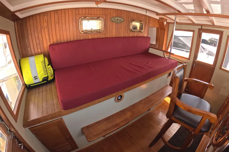 Slide: The Image of Interior of 1988 Kadey-Krogen 42 with red cushioned seating and wooden accents. - 21