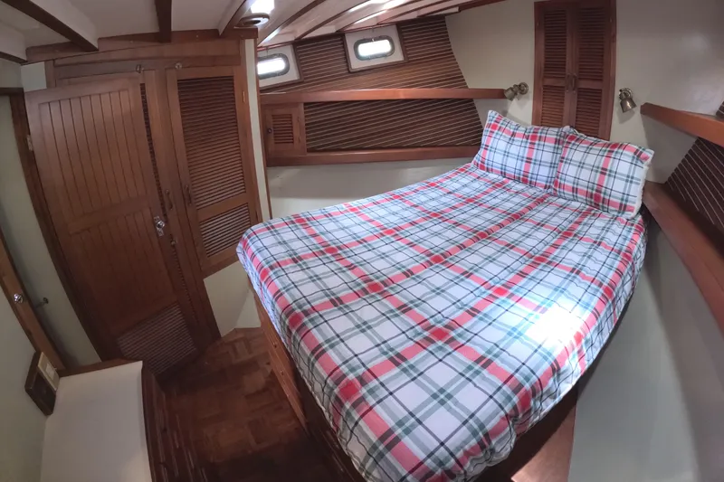 Slide: The Image of Cozy cabin interior of 1988 Kadey-Krogen 42 with plaid bedding and wooden accents. - 24