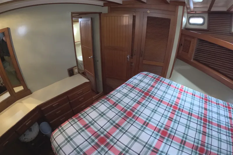 Slide: The Image of Cozy bedroom interior of 1988 Kadey-Krogen 42 yacht with plaid bedding and wooden furnishings. - 25