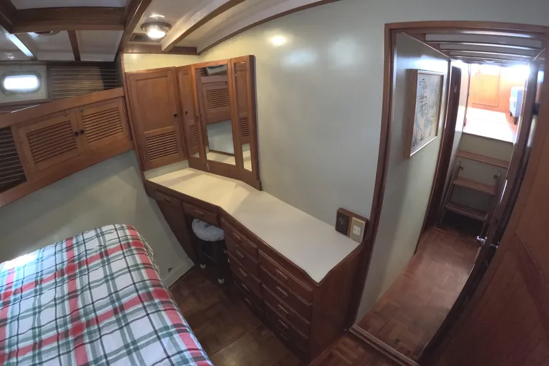 Slide: The Image of 1988 Kadey-Krogen 42 interior with wooden cabinetry and plaid bedding. - 26