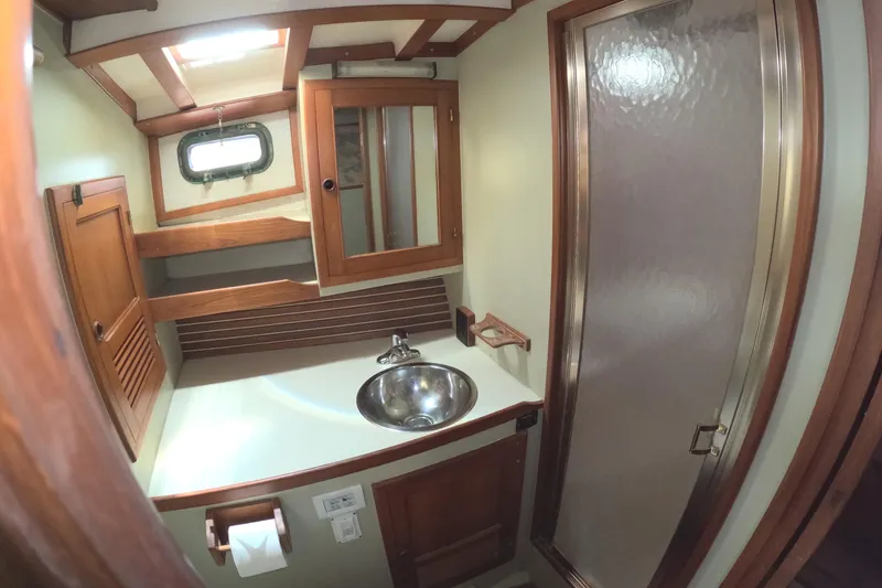 Slide: The Image of 1988 Kadey-Krogen 42 yacht bathroom with wooden cabinetry, sink, and shower. - 30
