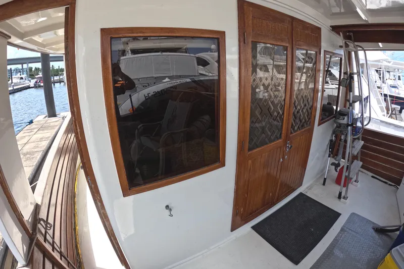 Slide: The Image of 1988 Kadey-Krogen 42 yacht deck with wooden doors and windows, docked at marina. - 42