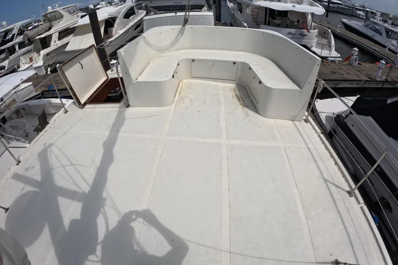 Slide: The Image of 1988 Kadey-Krogen 42 yacht deck with seating area, docked among other boats. - 44