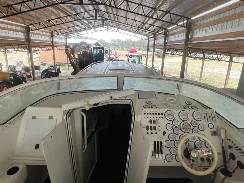 Slide: The Image of 1997 Fountain 47' Lightning boat cockpit with gauges, under a metal roof. - 14