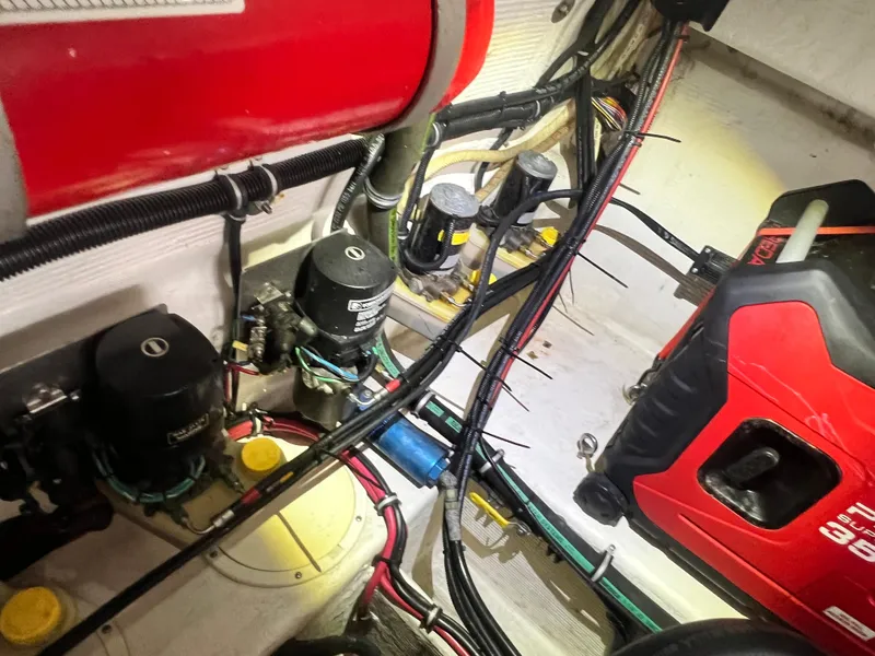 Slide: The Image of Engine compartment of a 1997 Fountain 47' Lightning boat, showcasing mechanical components and wiring. - 17