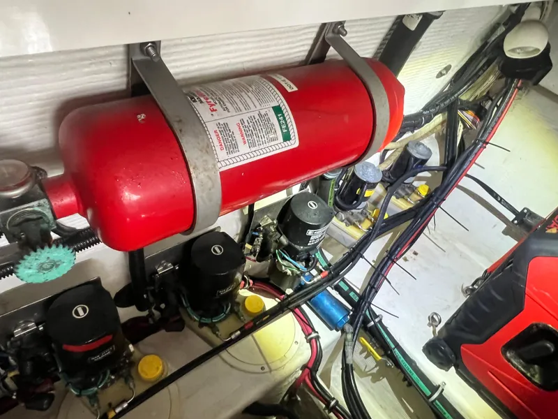 Slide: The Image of Engine compartment of 1997 Fountain 47' Lightning with fire extinguisher and wiring. - 18