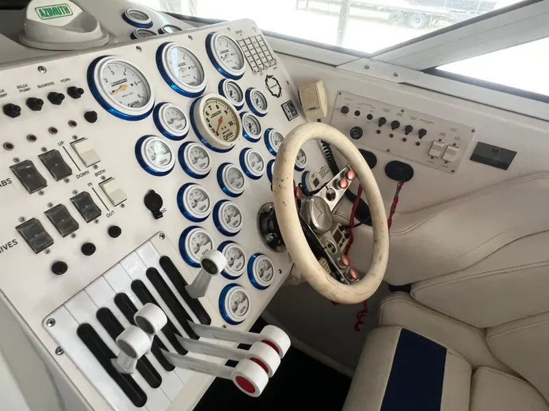 Slide: The Image of Control panel of a 1997 Fountain 47' Lightning boat with gauges and steering wheel. - 36
