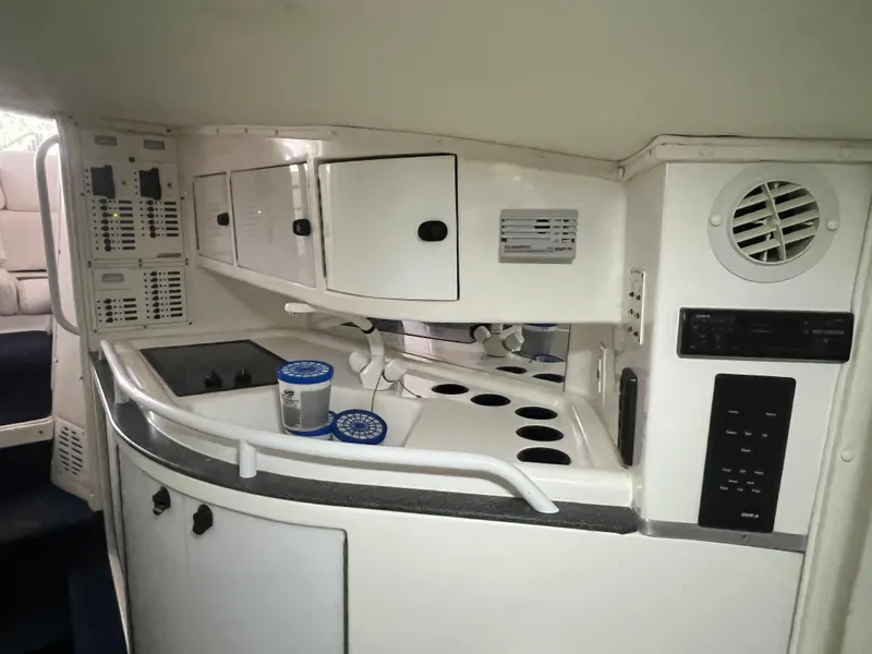 Slide: The Image of Interior of a 1997 Fountain 47' Lightning boat, featuring a compact kitchenette. - 38
