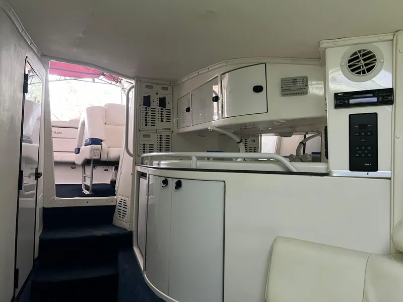 Slide: The Image of Interior of a 1997 Fountain 47' Lightning boat, featuring a compact kitchen area. - 39