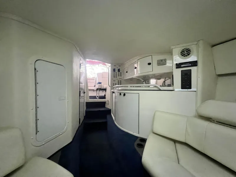 Slide: The Image of Interior of 1997 Fountain 47' Lightning boat, featuring white seating and compact kitchen area. - 40