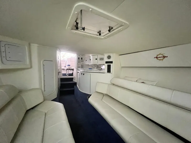 Slide: The Image of Interior of 1997 Fountain 47' Lightning boat with white seating and compact kitchen area. - 43