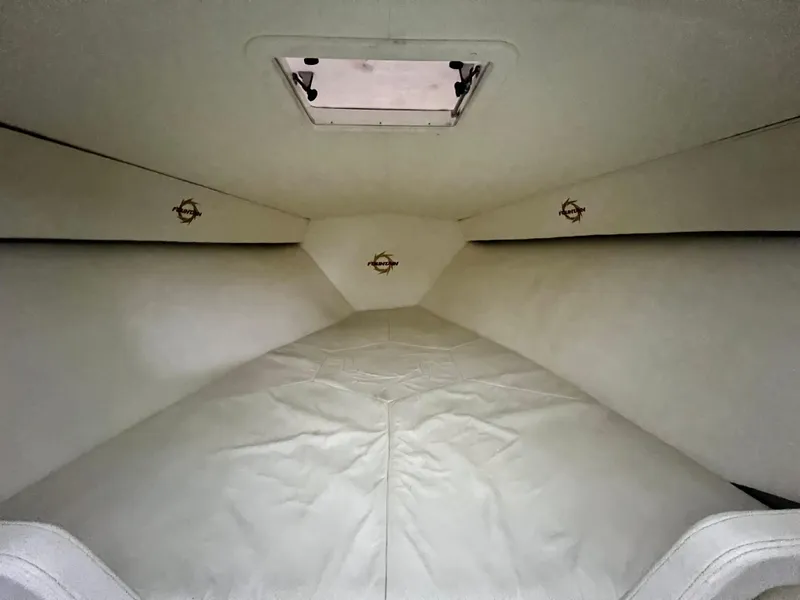 Slide: The Image of Interior cabin of 1997 Fountain 47' Lightning boat, featuring white upholstery and a ceiling hatch. - 44