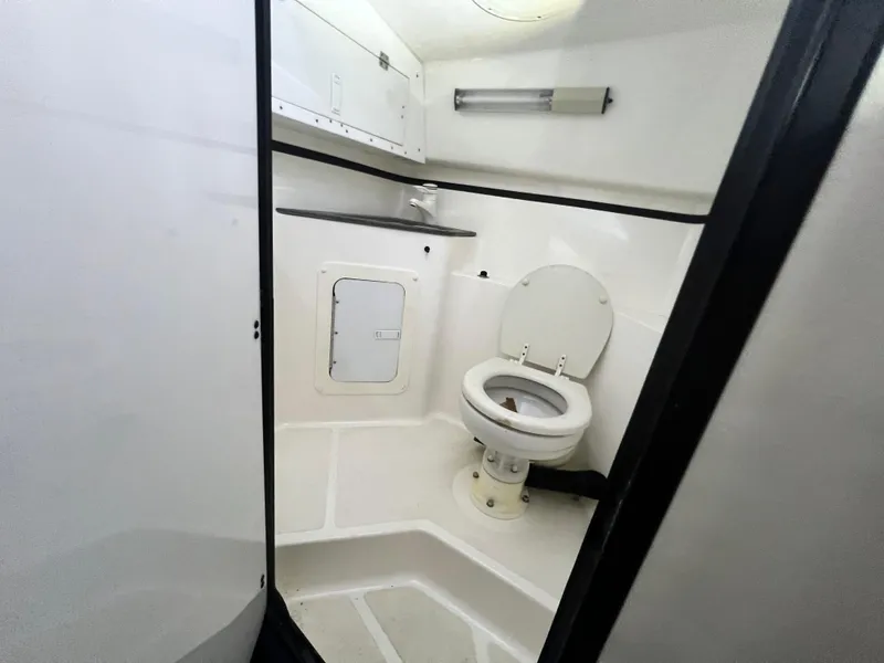Slide: The Image of Interior of 1997 Fountain 47' Lightning boat bathroom with toilet and storage. - 47