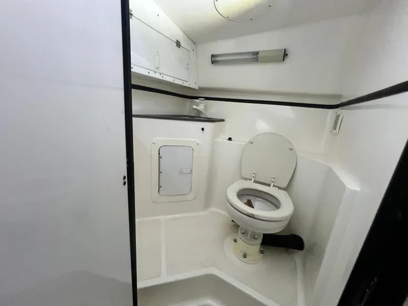 Slide: The Image of 1997 Fountain 47' Lightning boat bathroom interior with toilet and storage. - 48