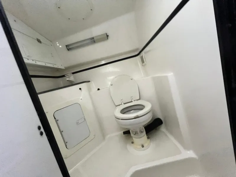 Slide: The Image of 1997 Fountain 47' Lightning boat bathroom interior with white fixtures. - 49