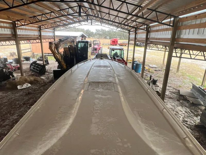 Slide: The Image of 1997 Fountain 47' Lightning boat stored in a metal shed with equipment. - 8