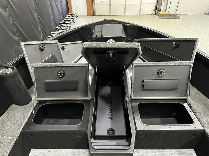 Slide: The Image of 2025 Alumacraft Competitor 185X Tiller boat with open storage compartments and sleek interior design. - 11