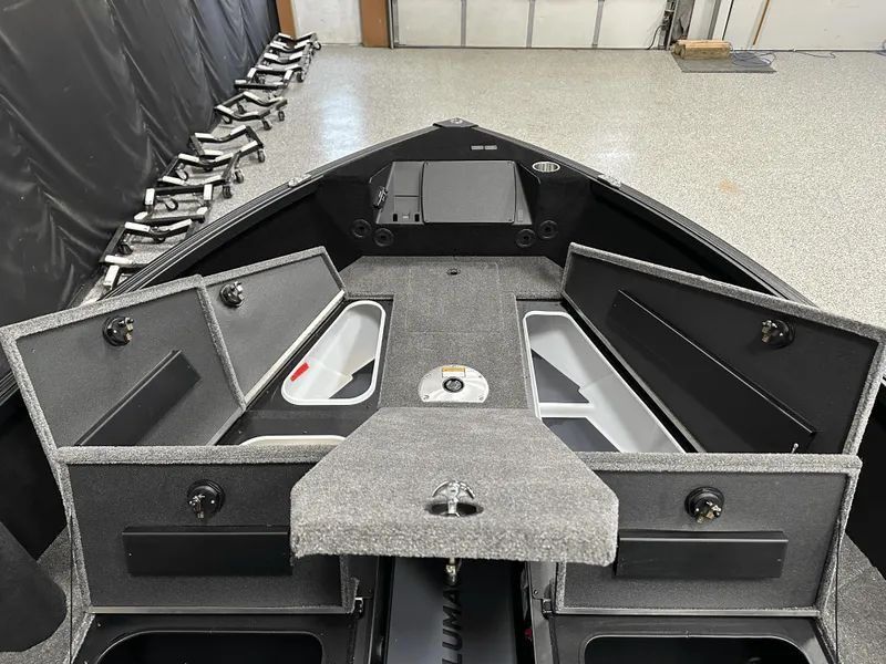 Slide: The Image of 2025 Alumacraft Competitor 185X Tiller boat interior with open storage compartments. - 12