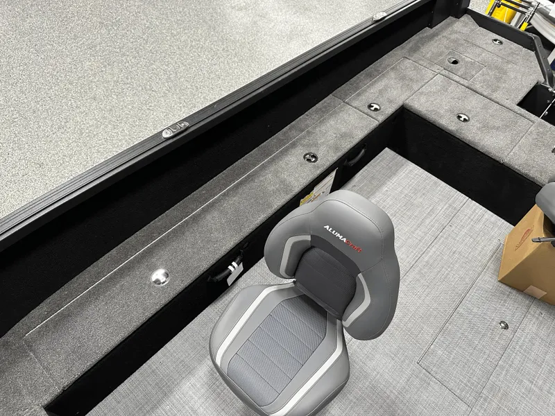 Slide: The Image of 2025 Alumacraft Competitor 185X Tiller interior with gray seating and storage compartments. - 15
