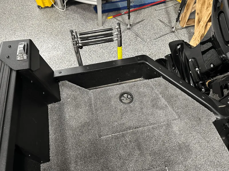 Slide: The Image of 2025 Alumacraft Competitor 185X Tiller boat interior with carpeted flooring and ladder. - 20