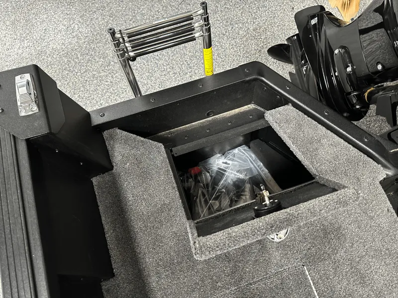 Slide: The Image of 2025 Alumacraft Competitor 185X Tiller boat interior with storage compartment and ladder. - 21