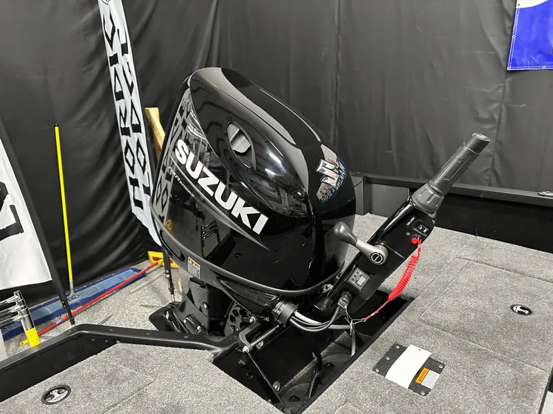 Slide: The Image of 2025 Alumacraft Competitor 185X Tiller with Suzuki outboard motor, displayed indoors. - 25
