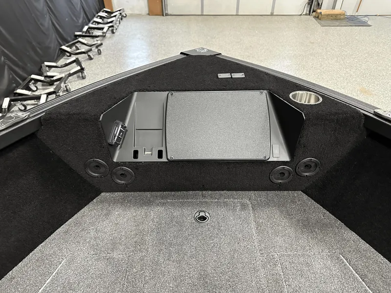 Slide: The Image of 2025 Alumacraft Competitor 185X Tiller boat interior, featuring storage and cup holder. - 9