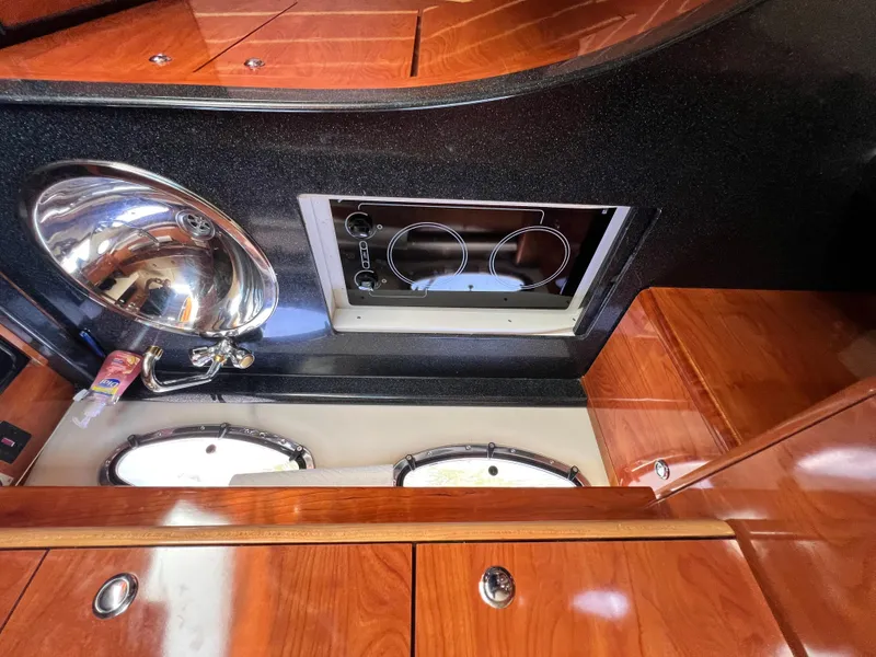 Slide: The Image of 2002 Regal Commodore 4260 yacht interior with sink, stove, and wooden cabinetry. - 15