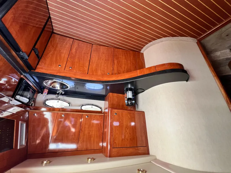 Slide: The Image of Luxurious interior of 2002 Regal Commodore 4260 yacht with wood cabinetry and modern amenities. - 19