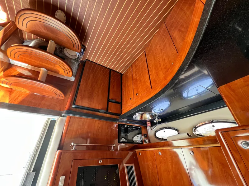Slide: The Image of Luxurious 2002 Regal Commodore 4260 yacht interior with polished wood cabinetry and modern amenities. - 21