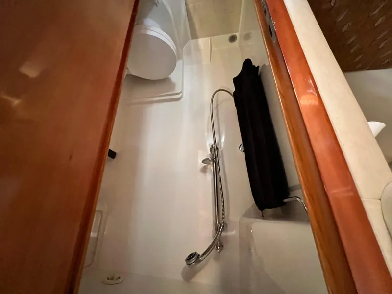 Slide: The Image of Interior of 2002 Regal Commodore 4260 yacht bathroom with shower and wooden accents. - 32