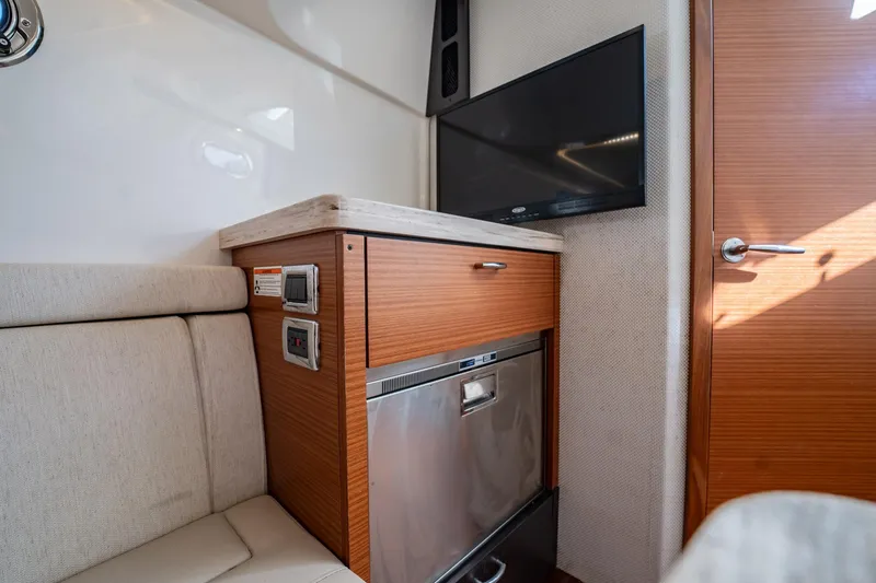 Slide: The Image of 2020 Pursuit S 408 Sport interior with TV, wooden cabinetry, and stainless steel appliances. - 14